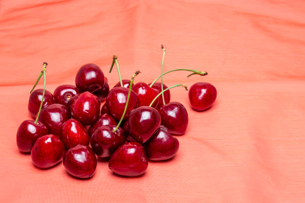 Red fresh cherries on on a red cloth background