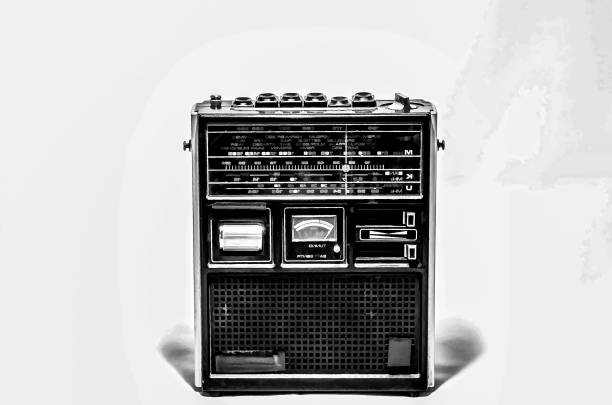 A vintage radio with a small screen and a dial. The radio is black and white