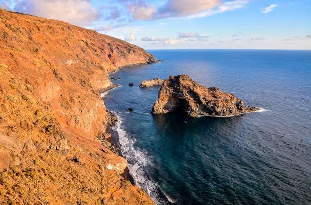 istock A rocky shoreline with a small rock in the water 2154331607