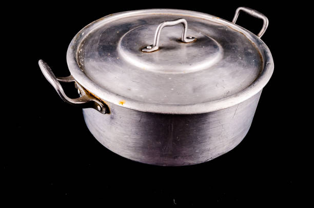 Preparing food by cooking in a pot on the stove next to an open door to a garden