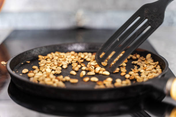 istock Green coffee is roasted in a cast-iron pan, stirred with a spatula. Coffee is brought to black. Selected focus 2154335183