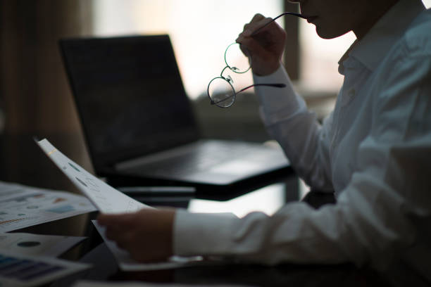 Businesswoman with short hair in a white shirt and black trousers working in an office environment and making a phone call