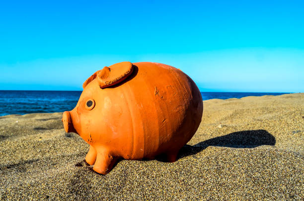 istock A piggy bank is sitting on the beach 2154339548