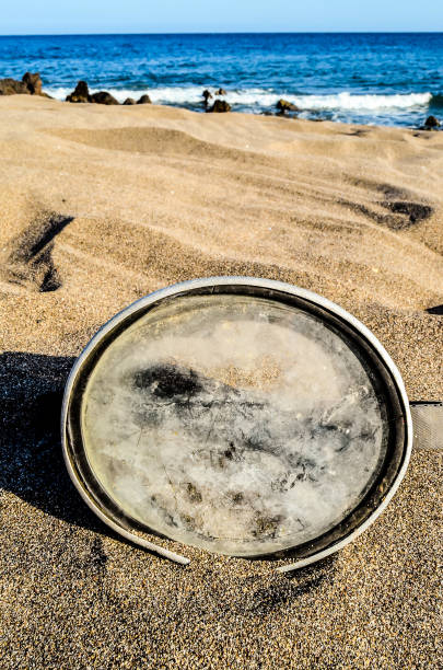 istock A silver bowl is sitting on the sand next to the ocean 2154339562