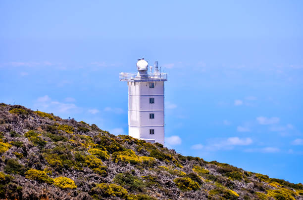 istock A tall white tower is on a hill overlooking the ocean 2154339581