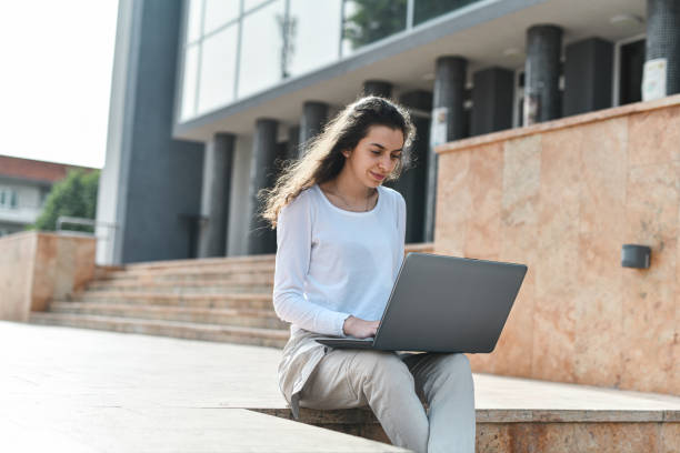 istock Beautiful Female Using Laptop To Do Work Related Tasks Outside 2154339745