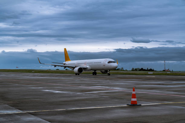 istock Airplane on Wet Tarmac Under Cloudy Sky 2154342011