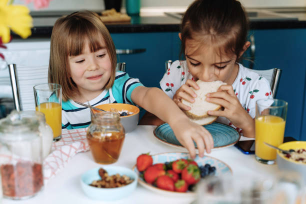 istock Happy kids enjoying breakfast and sandwich 2154342842