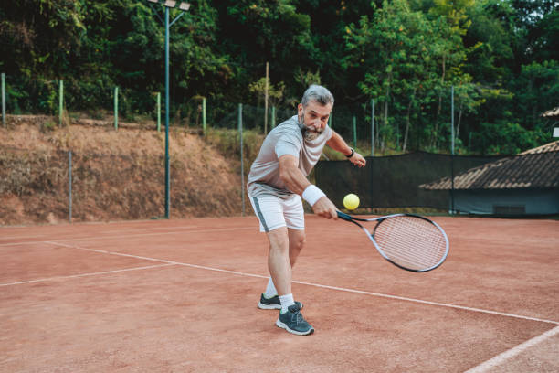 istock senior man playing tennis hitting the ball 2154343246