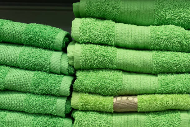 Towel. Household goods. Textile industry. Retail trade. A stack of green towels.
