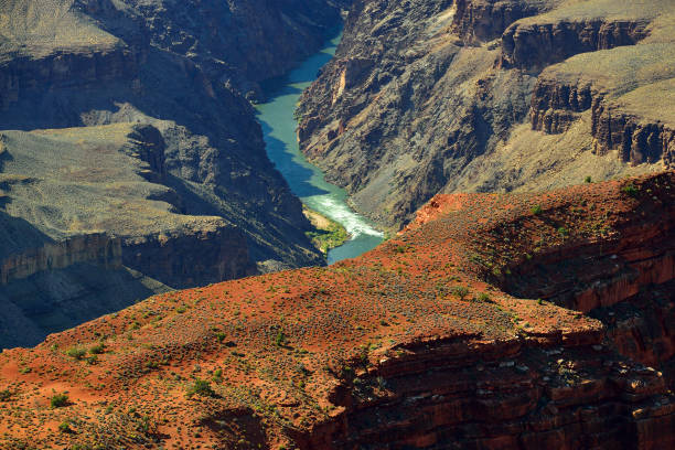 Colorado river flowing through rugged Grand Canyon National Park presenting a colorful spectacle to the tourists from South Rim.