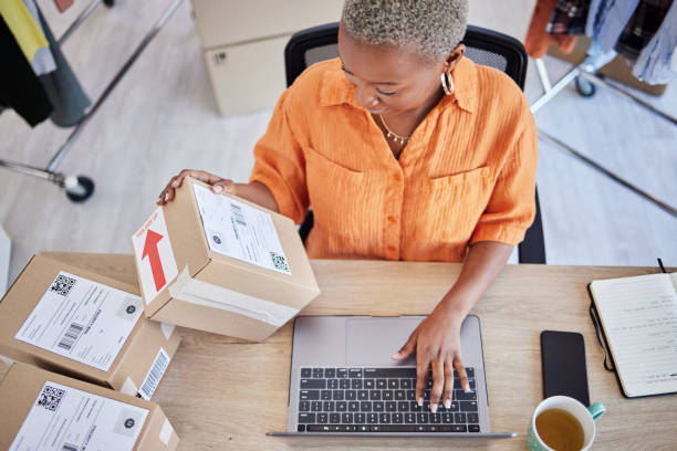 Laptop, logistics or black woman with box for shipping, delivery or package in ecommerce in office. Online, stock or business owner with product label or store order for cargo service or sticker sign laptop, logística o mujer negra con caja para envío, entrega o paquetería en ecommerce online. escribiendo, arriba o propietario de la empresa con la etiqueta del producto o el pedido de la tienda para el servicio de carga o la etiqueta adhesiva