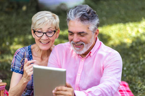 istock Senior couple sitting on blanket and using digital tablet 2154351001