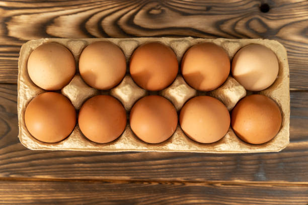 istock Brown chicken eggs stored in a carton on a rustic wooden table 2154351038