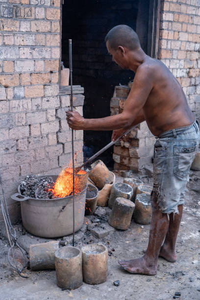 Andasibe, Madagascar - One men working with burning material, waist material, they use for making new aluminum cooking pots. Andasibe, east from the Antananarivo.
