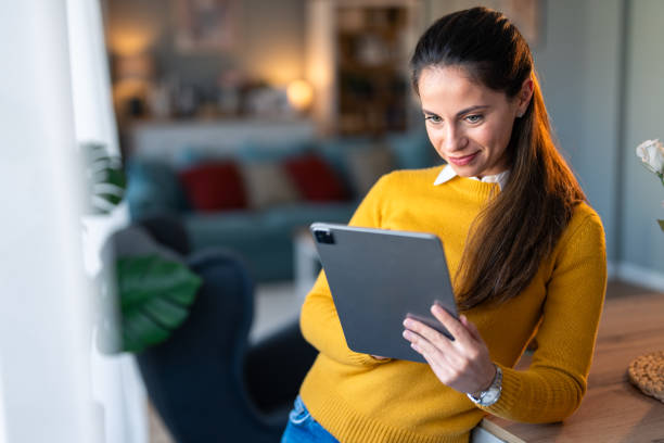 istock Smiling woman entrepreneur working from home over digital tablet 2154358887