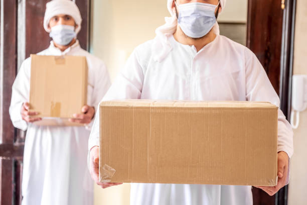 istock Arabic man holding box of cartoon 2154360286