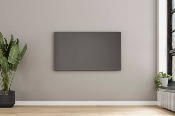A modern living room with a white screen TV mounted on the wall, windows and decoration