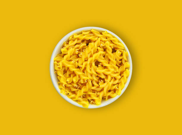 istock yellow noodles with a plate on a yellow background. 2154362913