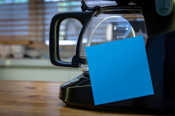 Blank blue sticky note on the coffee machine in the kitchen.