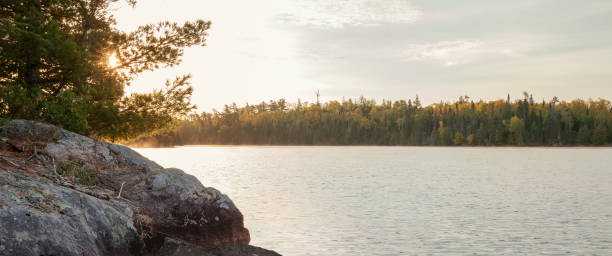 istock Sunrise behind rocks and pines on a boundary waters lake during autumn 2154367256