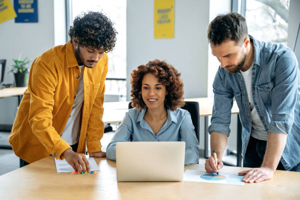 istock Successful people of different nationalities, creative business team, working together on a project in a modern office, watching presentation, discussing ideas, brainstorming. Teamwork, collaboration 2154369184