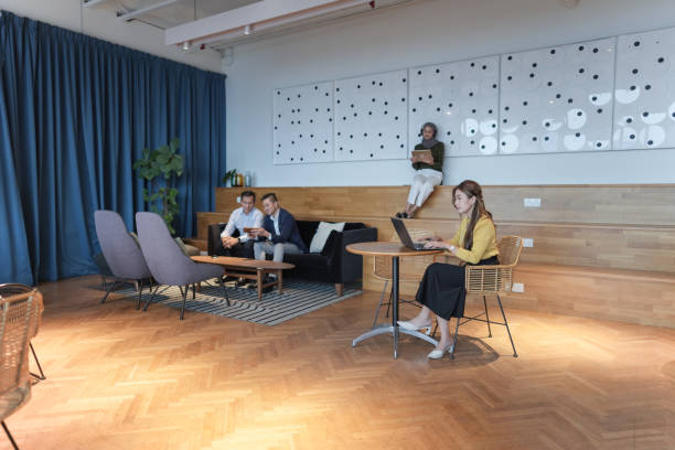 Three colleagues engaging actively in teamwork, surrounded by greenery and natural light.