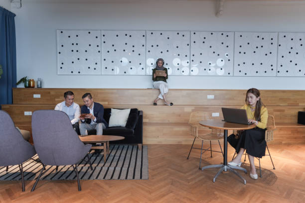 Business team meeting in contemporary business center, talking at office conference table, negotiating on project in modern interior with big panoramic window. Through glass view background