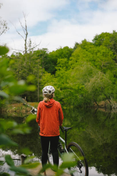 istock Road bicyclist relaxes by lake in forest 2154371891