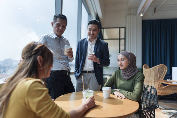 istock A diverse group of colleagues in casual conversation while enjoying coffee at a modern office cafe 2154371940