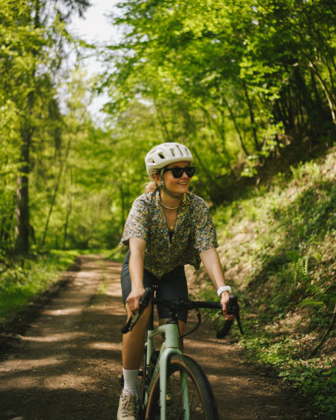 istock Road bicyclist rides through lush forest 2154372128