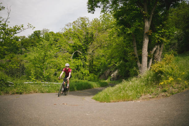 istock Road bicyclist rides country road 2154372132