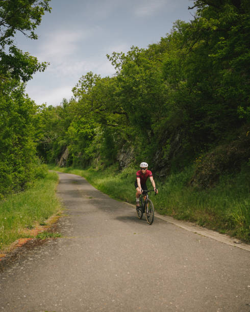 istock Road bicyclist rides country road 2154372181