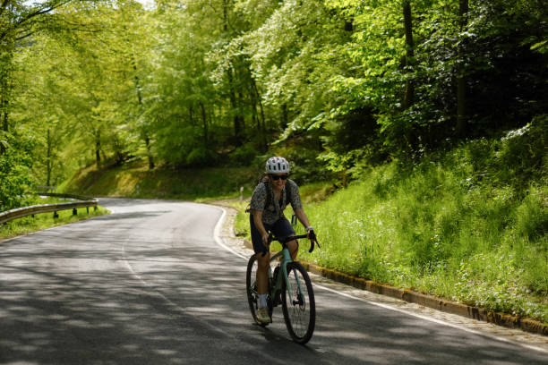 istock Road bicyclist rides country road 2154372214