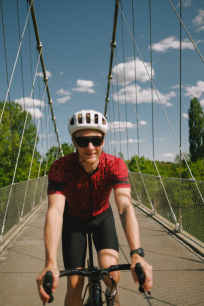 istock Road bicyclist rides across suspension bridge 2154372254