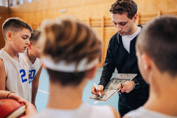 istock Basketball coach working on game strategy with his junior team at court 2154373045