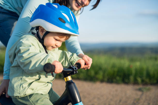 istock A toddler learning how to ride a bike with his mom. 2154373421