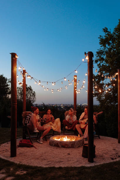 istock Friends sitting by a fire pit in the garden, singing and having fun. 2154373818