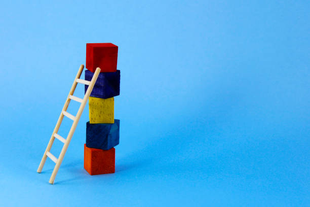 istock Ladder supported on column formed with cubes of different colors 2154376299