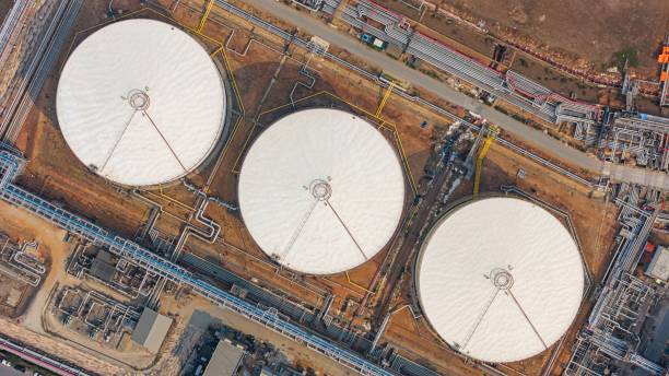 Aerial top view oil terminal storage tank at night.