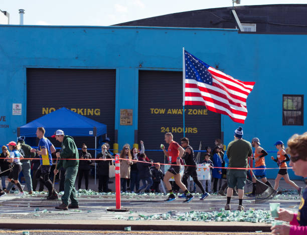 USA Flag Holder at 2019 New York Marathon New York Marathon runners pass by near Cobble Hill in Brooklyn as one runner carries USA flag during the run new york marathon photos stock pictures, royalty-free photos & images