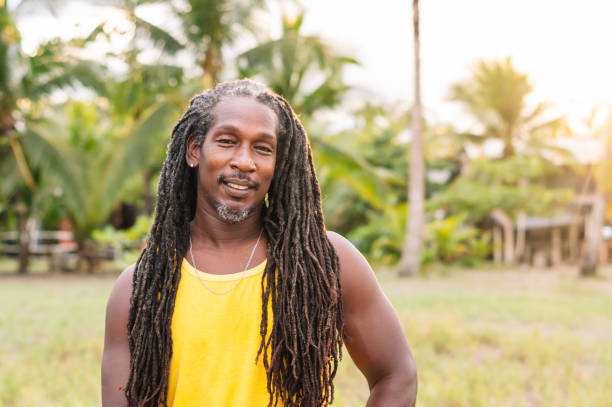 Caribbean man posing for the camera with a smile. Horizontal image of black man with long hair.