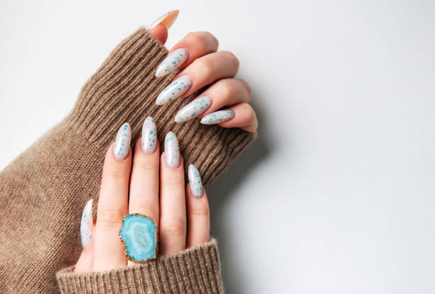 istock Hands with blue nail polish on cozy sweater 2154392381