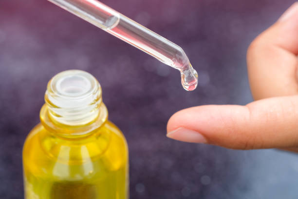 istock Dropping serum collagen moisturizer of face into clear yellow bottle soft light background. Protector skin Treatment facial essence oil, Vitamin C. Beauty and spa Concept. 2154394296