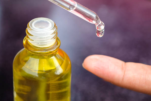 istock Dropping serum collagen moisturizer of face into clear yellow bottle soft light background. Protector skin Treatment facial essence oil, Vitamin C. Beauty and spa Concept. 2154394301