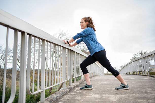 istock Young woman stretching her legs on a bridge before a run 2154398058