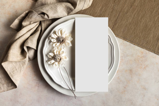 Wedding menu card and white flowers on plates mockup top view