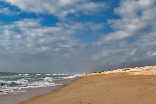 istock Lonely beach with sun-lit dunes under a cloudy sky 2154404539