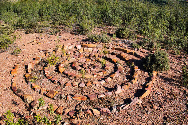 Stones of different colours, laid out in a spiral and circular pattern Stones of different colours, laid out in a spiral and circular pattern, in the cistus-covered hills near Vale Fuzeiros, Algarve, Portugal spiral rock stock pictures, royalty-free photos & images