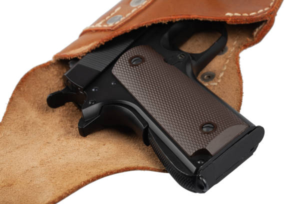 Automatic Pistol, Caliber .45 in holster Automatic Pistol, Caliber .45 in holster isolated on white background forty five caliber handgun stock pictures, royalty-free photos & images